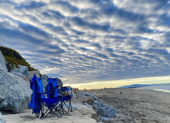 A beach with a row of blue folding chairs and a rocky outcrop. - Beautiful Oceanfront, just steps to the beach, Fireplace, Remote location (Watsonville)