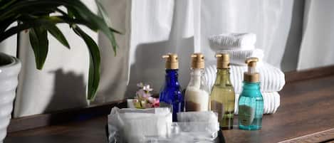 A tray with toiletries including a toothbrush, toothpaste, and a bottle of mouthwash on a wooden surface.