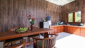 Ein Holztisch mit Stühlen, eine Blumenvase und eine Obstschale.