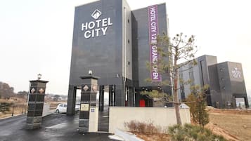 A modern hotel building with the name "HOTEL CITY" prominently displayed on the facade.