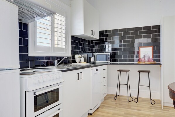 Enjoy cooking in this stylish kitchen with appliances, a stovetop, oven, and microwave.