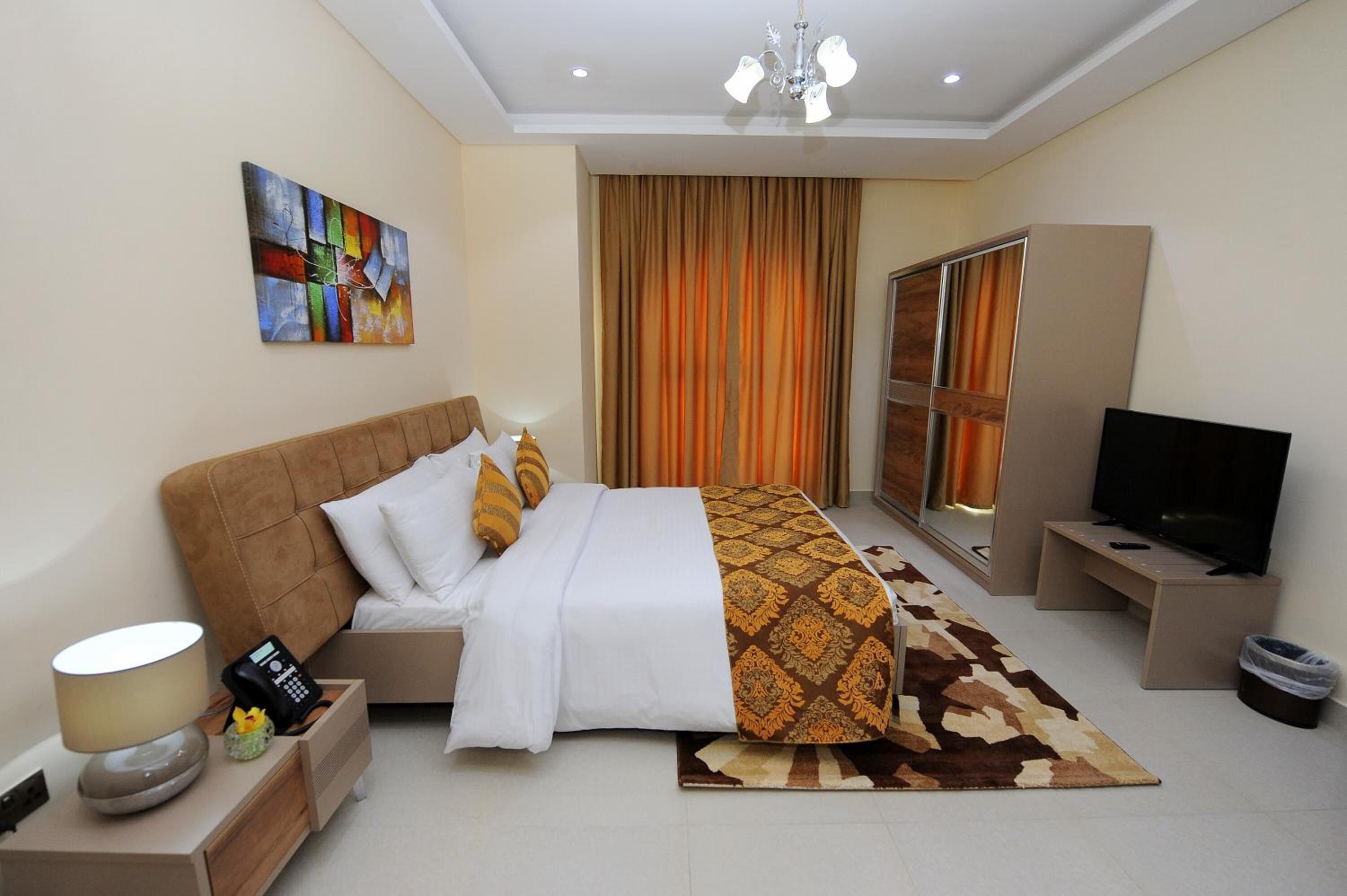 A hotel room with a bed, bedside tables, a TV, a painting, and a large window with curtains.
