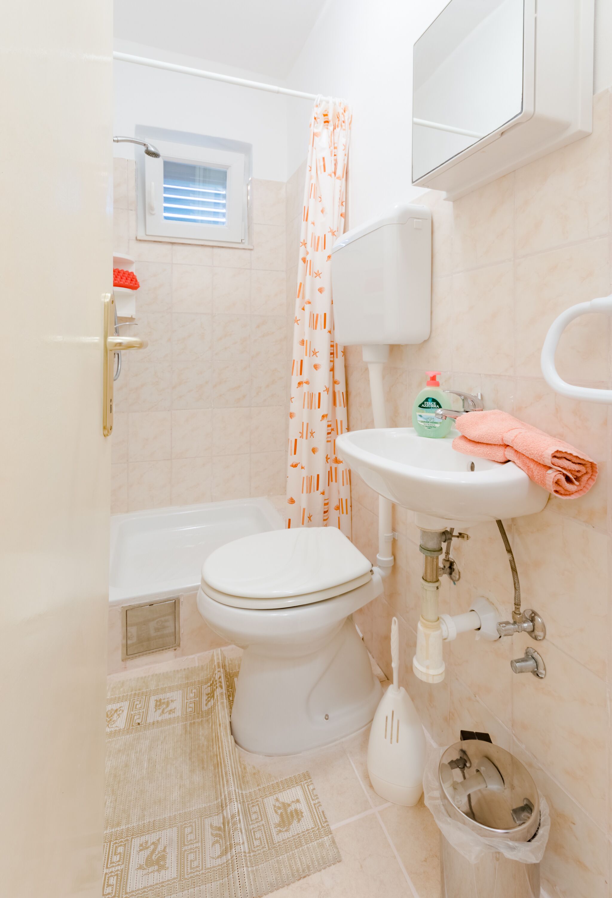 A bathroom with a toilet, sink, and shower.