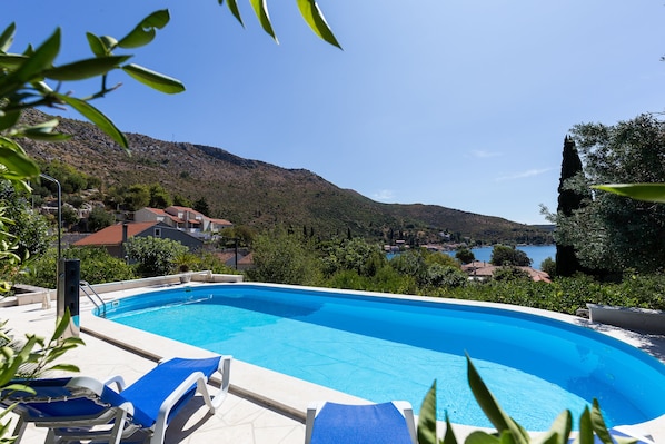 Una piscina al aire libre, sillones reclinables de piscina