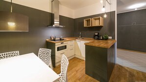 Una cocina moderna con una isla central, armarios blancos y un horno empotrado.