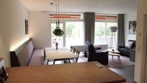A modern living room with a dining area, a sofa, and a coffee table.