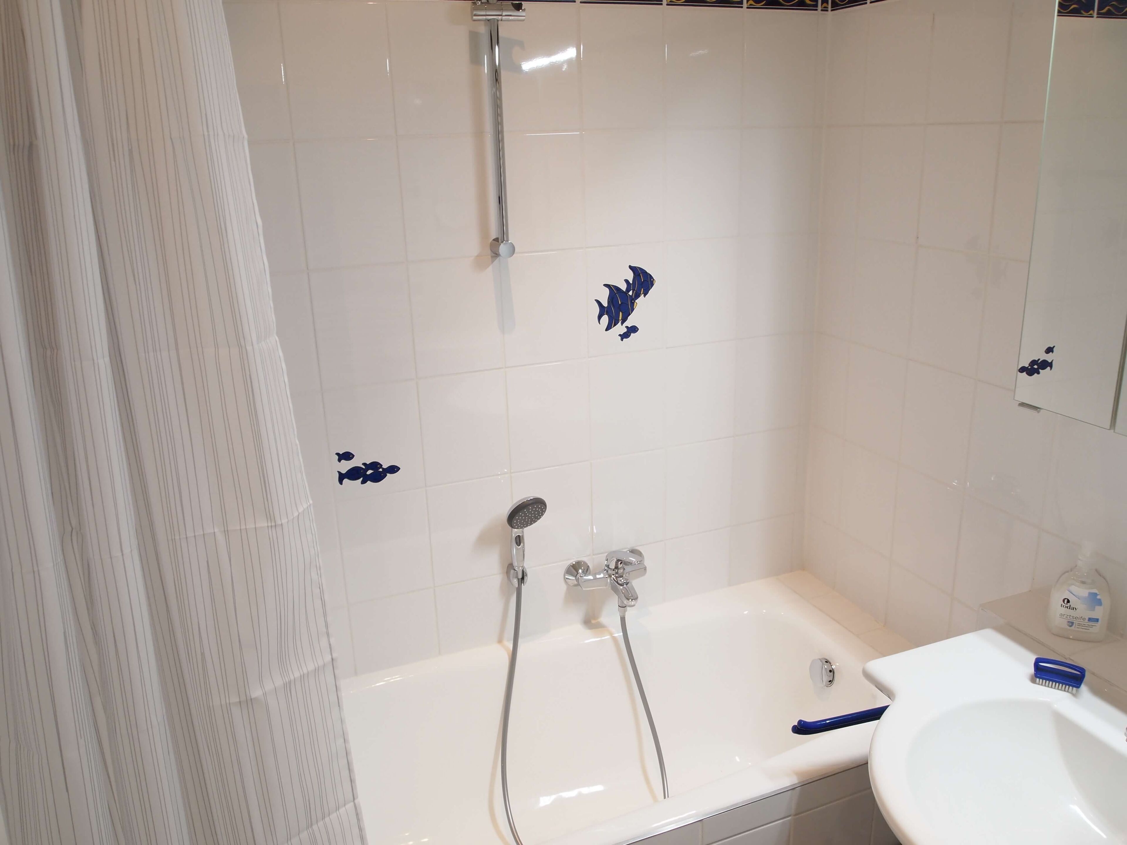 Un baño con bañera, ducha y lavamanos.