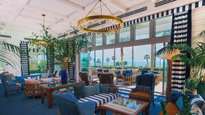 A spacious lounge area with comfortable seating, large windows offering a view of the ocean, and a ceiling with a distinctive circular light fixture. - The Seabird Ocean Resort & Spa, Part of Destination Hotel by Hyatt (Oceanside)