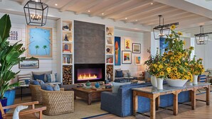 A cozy living room with a fireplace, comfortable seating, and a large bookshelf. - The Seabird Ocean Resort & Spa, Part of Destination Hotel by Hyatt (Oceanside)