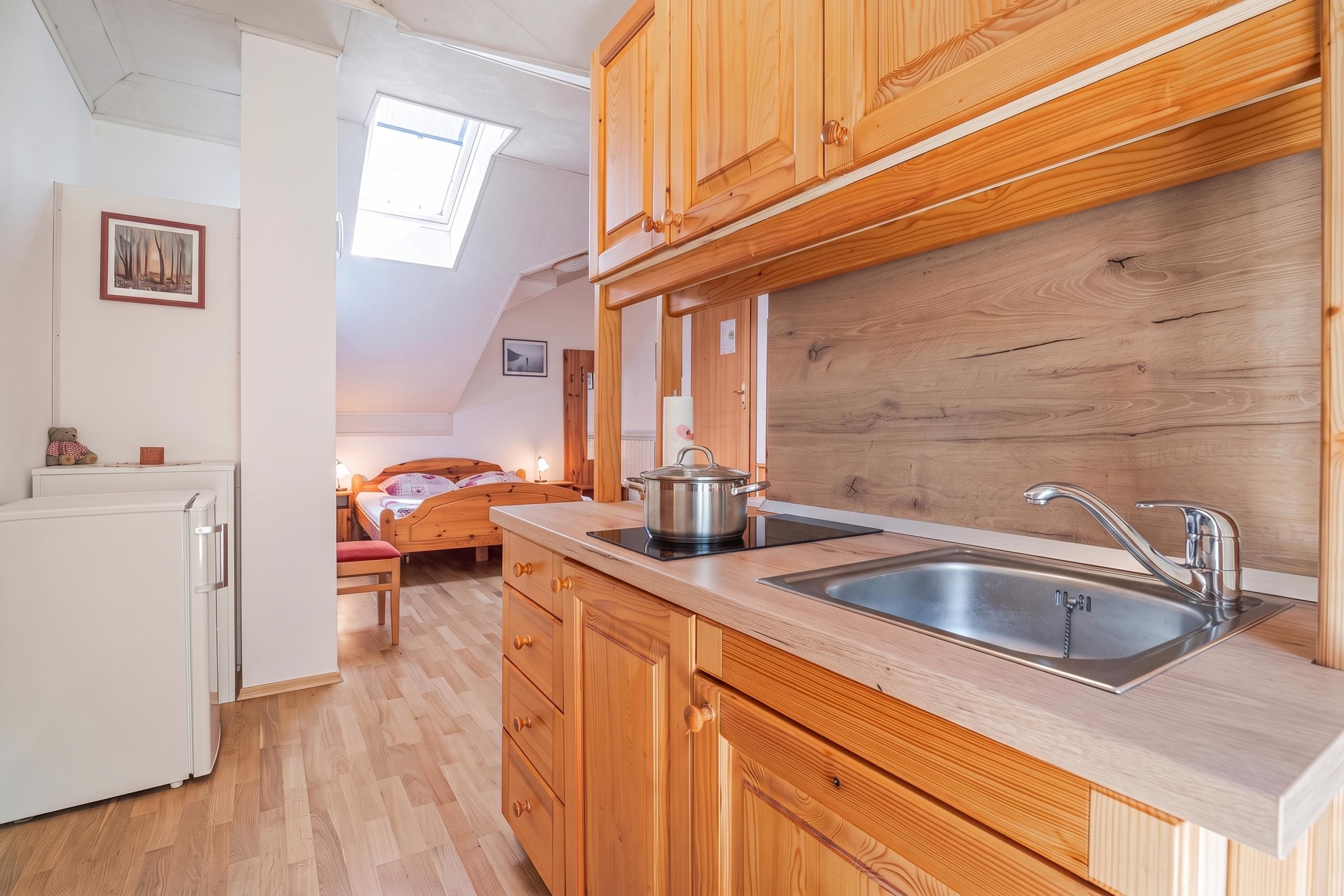 A compact kitchen with wooden cabinets, a sink, and a stove.