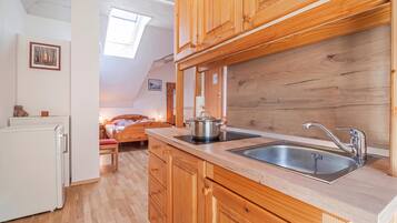 A compact kitchen with wooden cabinets, a sink, and a stove.