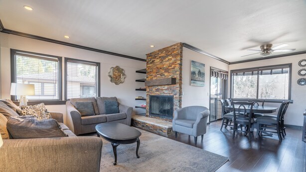 A living room with a fireplace, a dining area, and a seating area with a sofa and armchairs.