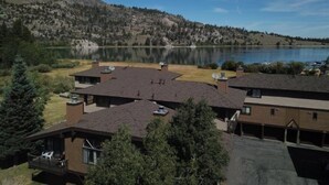 A residential area with houses, a lake, and a mountainous backdrop.