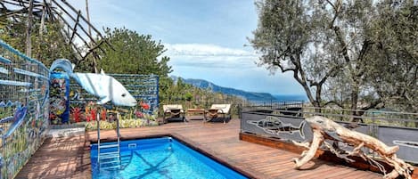 Una piscina al aire libre de temporada, sillones reclinables de piscina