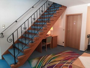 A wooden staircase with blue carpeted steps and black wrought iron railings. - Staufenberg Vacation Rental - House in Wolfsbach - Vacation Apartments (Walkenried)
