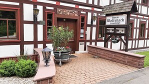 En traditionell byggnad med korsvirkesfasad, med en skylt som visar texten ”Haus am Moltsbach” och en ölkran märkt ”Einbecker”.
