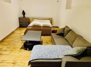 A room with a bed, a sofa, a small table, and a nightstand. - Very nice 80 m2 apartment (Pianottoli-Caldarello)