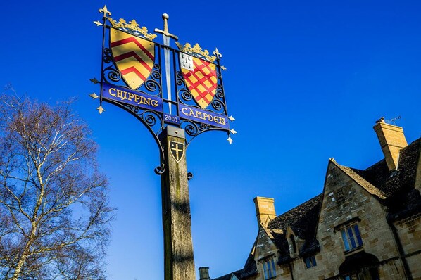 A sign with two coats of arms, one for Chipping and one for Campden, mounted on a post. - Noel Cottage - Central Cotswolds Stone Cottage For Two In Chipping Campden (Chipping Campden)