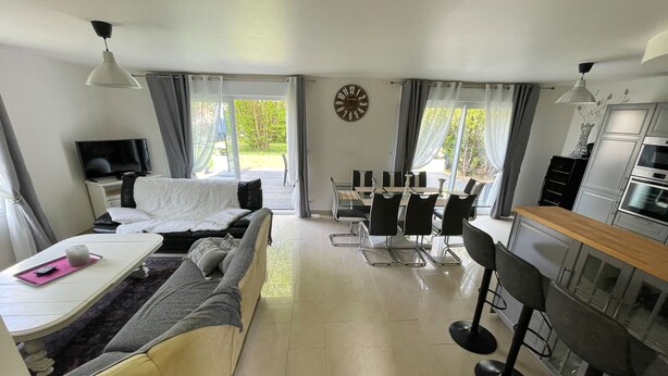 Une chambre d’hôtel moderne équipée d’un canapé, d’une table à manger avec des chaises, d’un coin cuisine et d’un téléviseur.