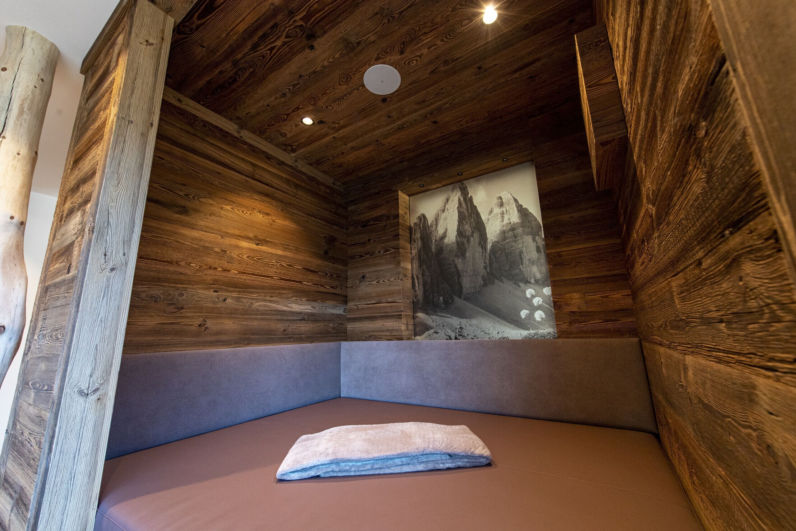 Ein gemütliches Zimmer mit Holzwänden und einer gepolsterten Bank.