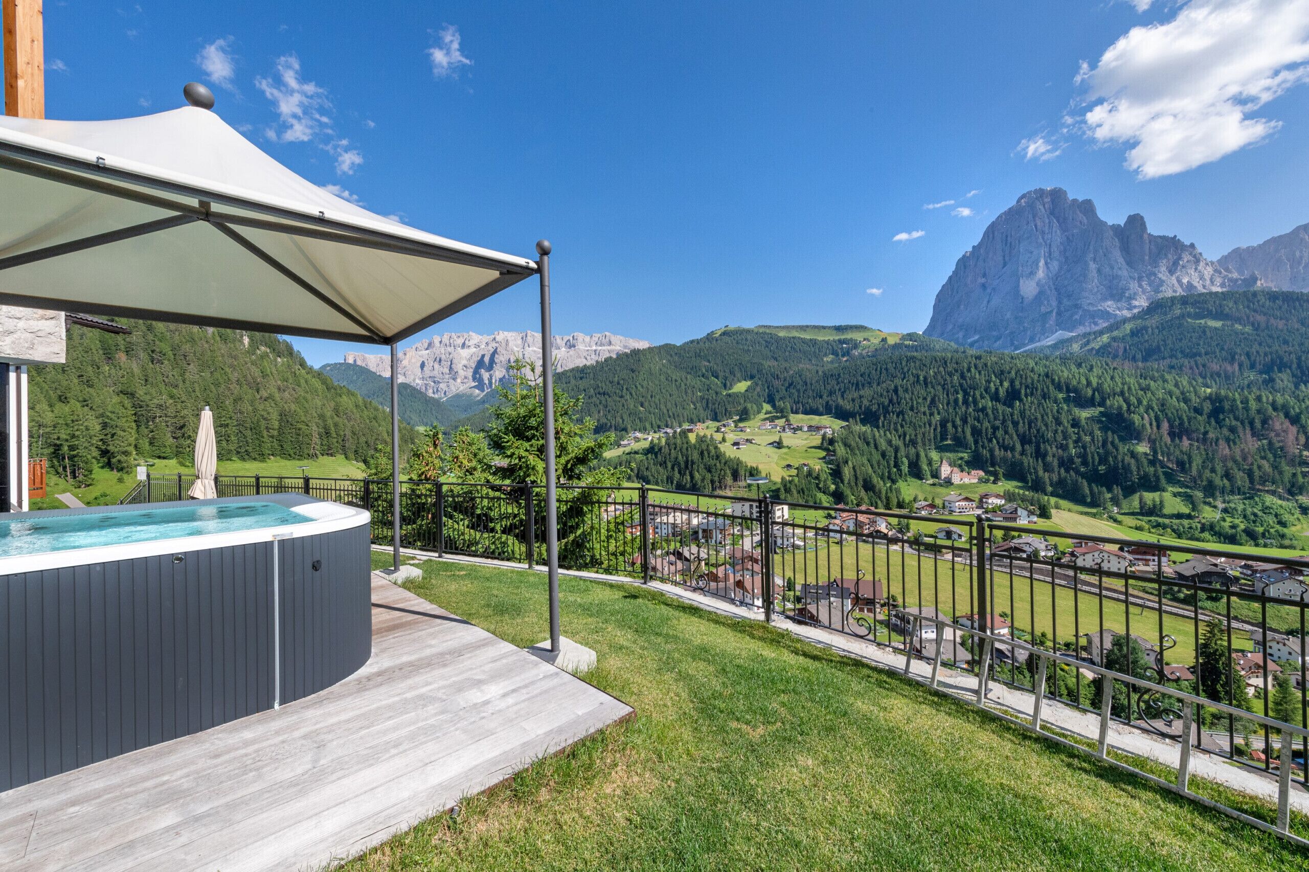 Un bain à remous doté d’un auvent, une terrasse en bois et une vue panoramique sur les montagnes.