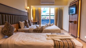 A hotel room with two beds, a television, and a view of the outside. - Rudra Shelter Business Hotel (Vasai)