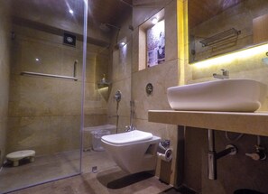 A modern bathroom with a glass-enclosed shower, a toilet, and a sink with a mirror above. - Rudra Shelter Business Hotel (Vasai)