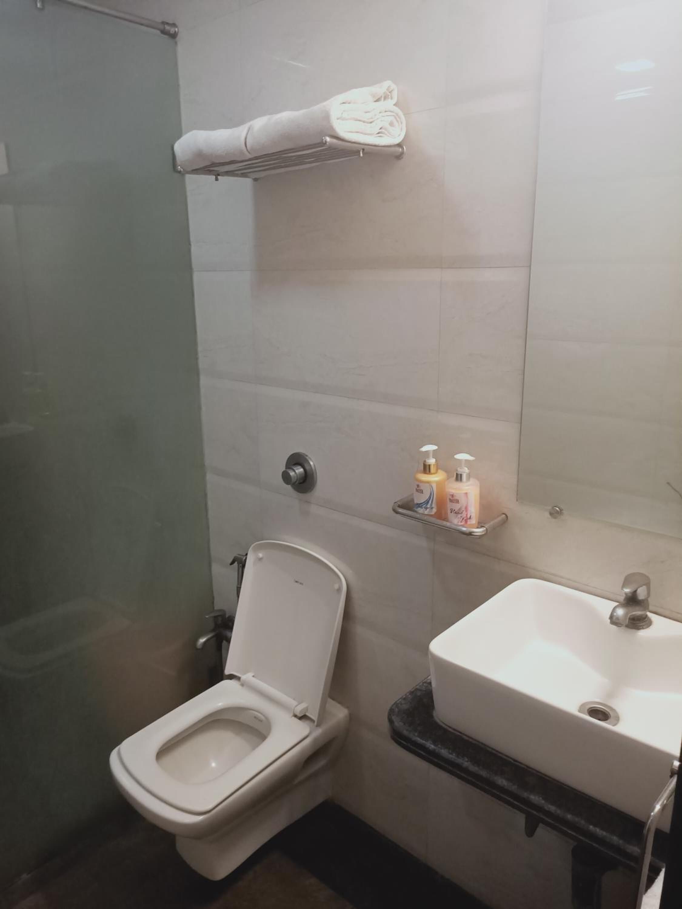 A bathroom with a toilet, a sink, and a towel rack.