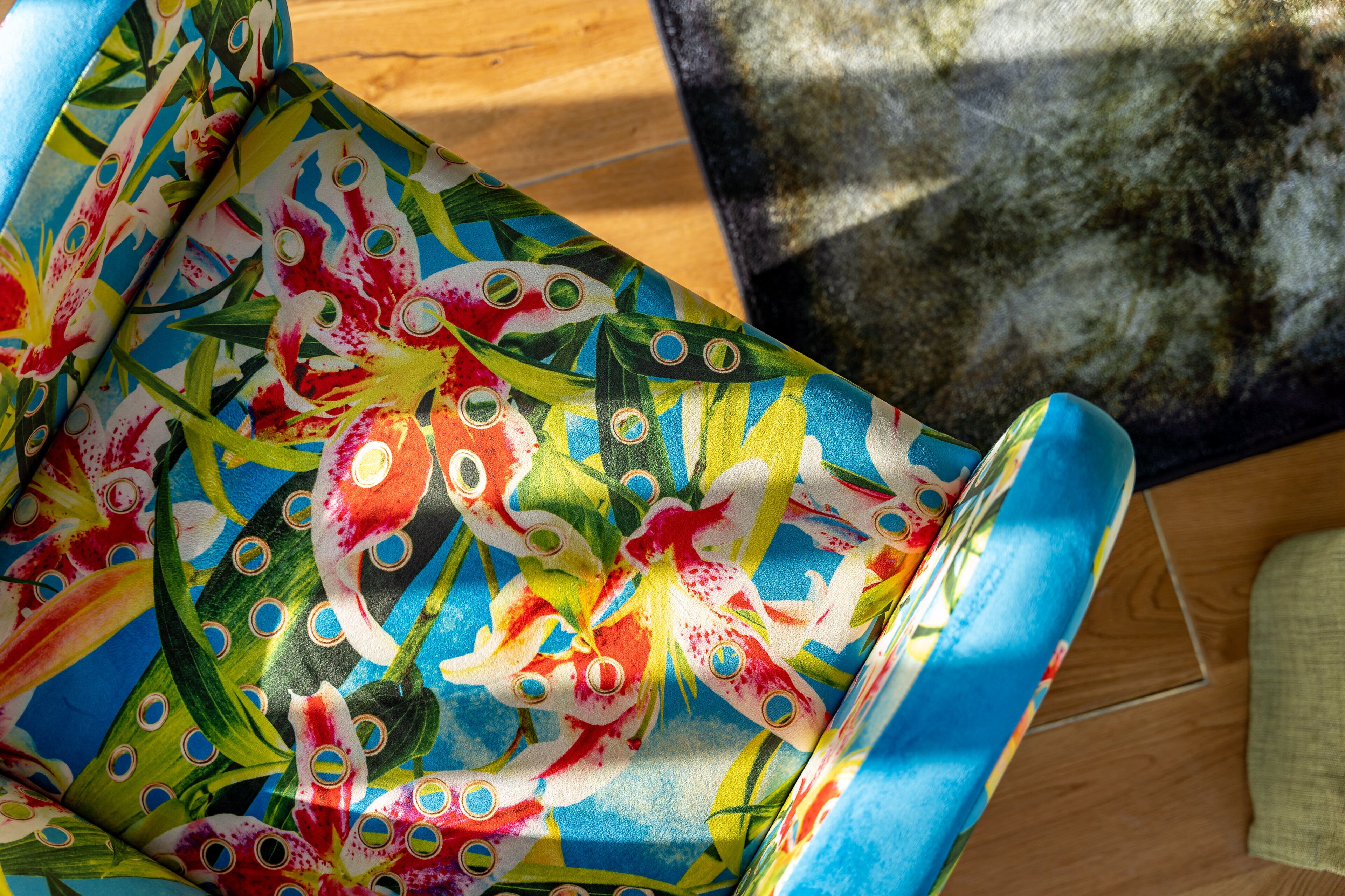 Tejido colorido con un estampado floral, posiblemente un mantel o adorno decorativo.