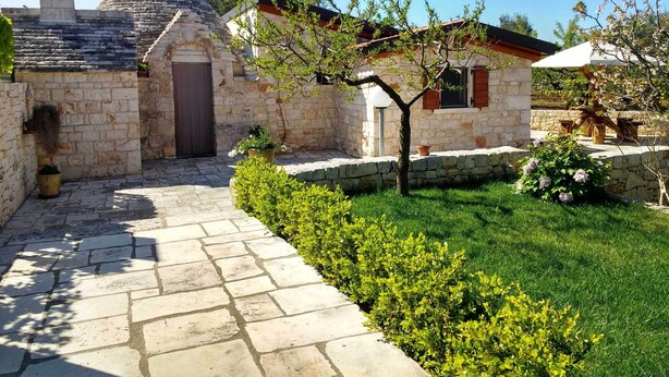 A stone building with a conical roof, a small door, and a window with shutters. - Trullo Degli Ulivi (Castellana Grotte)