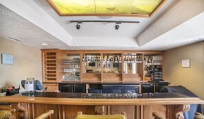 A bar area with a wooden counter, wine glasses, and bottles. There are cabinets with various items and a ceiling light. - Family Vacation~Heated In/Out Pool, Tubing & Ice Skating Villa 1076 (Midway)