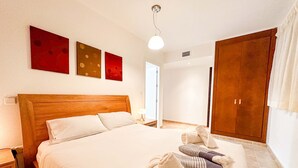 Ein Hotelzimmer mit einem großen Bett, einem hölzernen Kopfteil und drei Wandbildern.