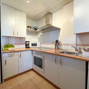 A compact kitchen with white cabinets, a microwave, a coffee maker, and a sink. - Modern 3 Bedroom Duplex with Large Sunlit Terrace Southwest facing BIS02 (Ayamonte)