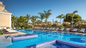 A clear blue pool with tiled steps, surrounded by lounge chairs and palm trees. - Barcelo La Nucía Hills (La Nucia)