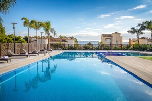 Een buitenzwembad, parasols voor strand/zwembad