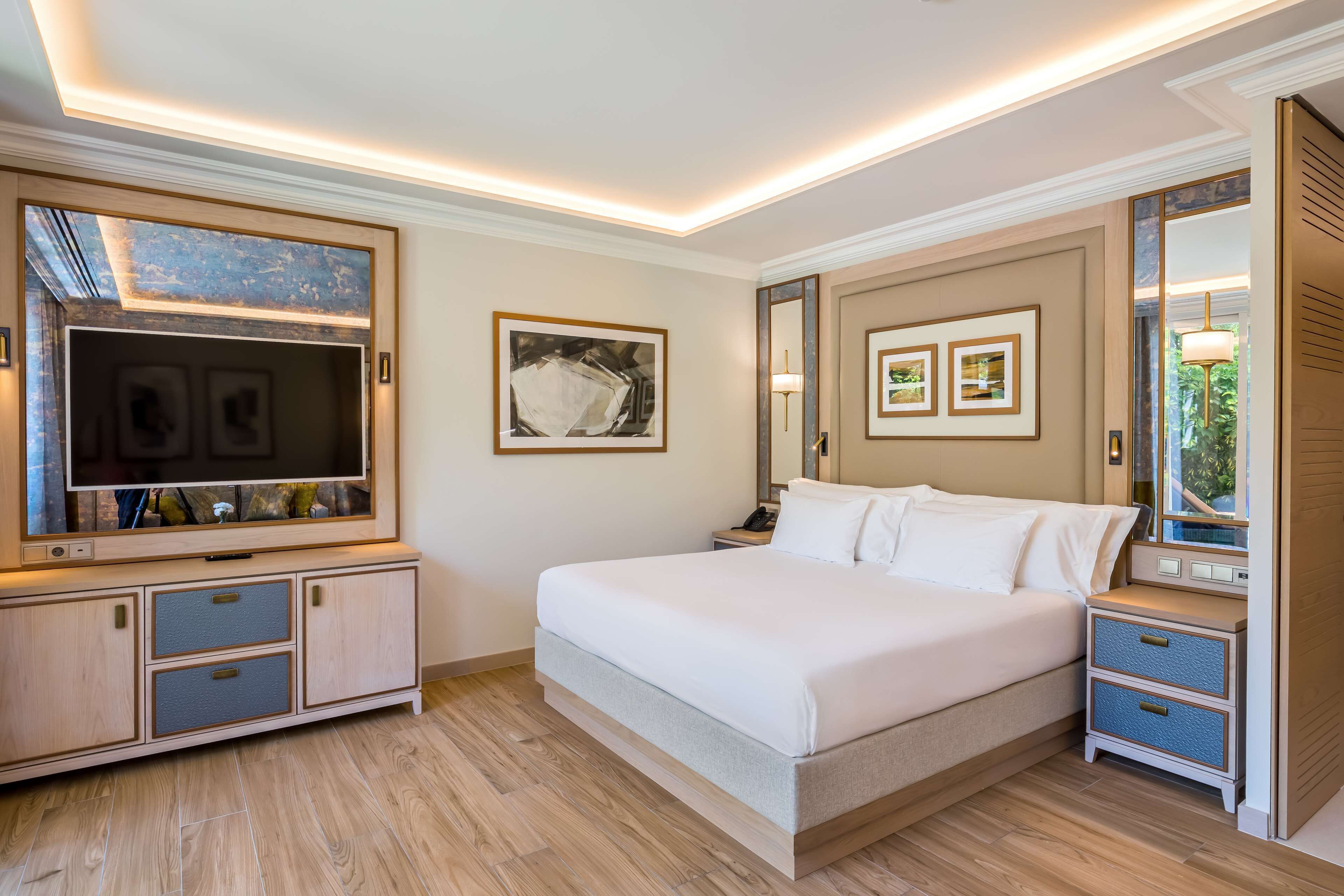 Une chambre moderne avec un grand lit, une télévision et une armoire.