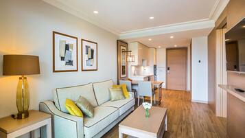 A modern living room with a sofa, coffee table, and a dining area.