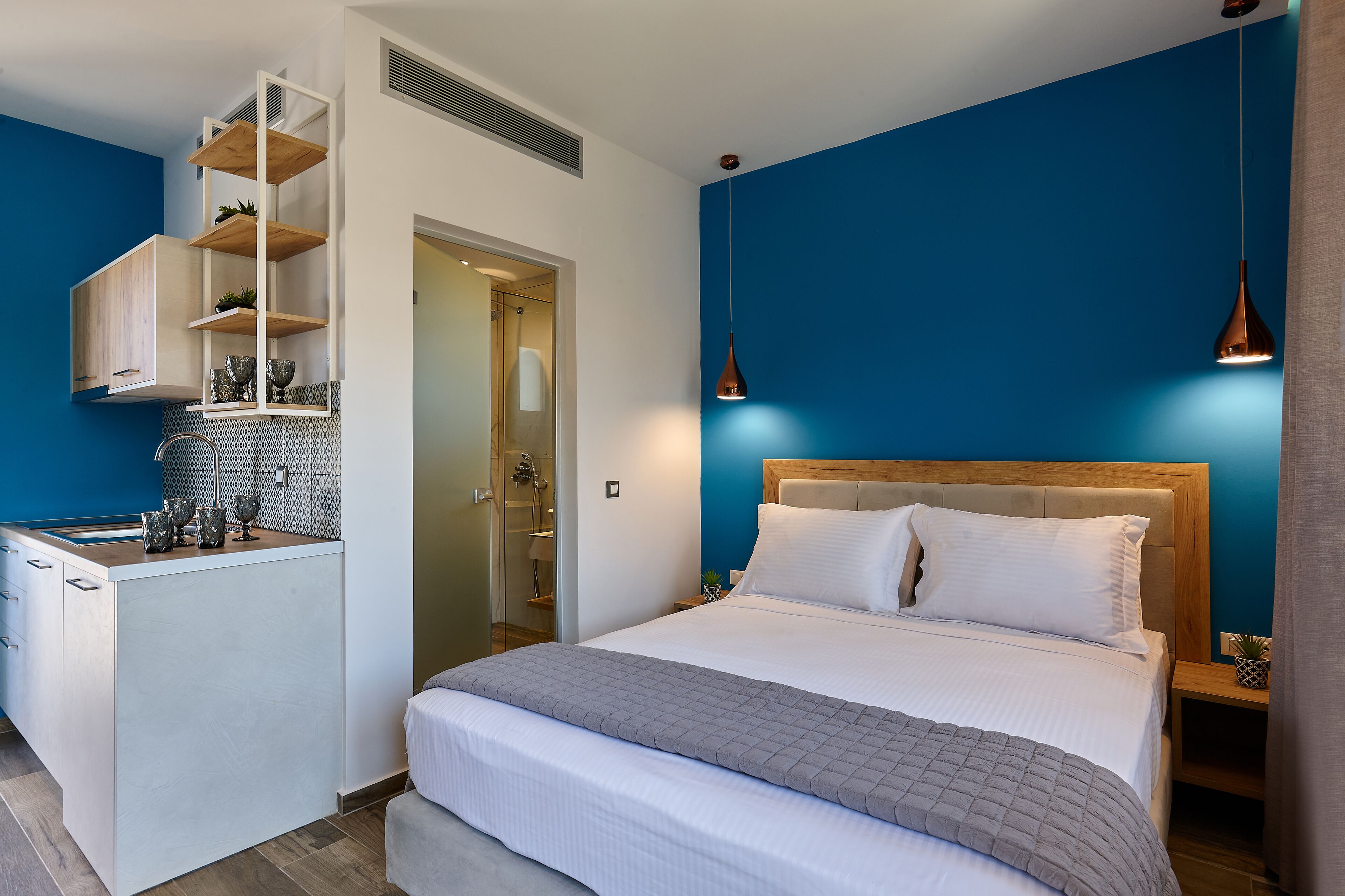 A bedroom with a bed, bedside tables, a wardrobe, and a built-in shelf unit.