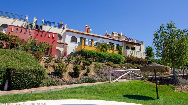 A hotel with multiple buildings, a swimming pool, and landscaped gardens.