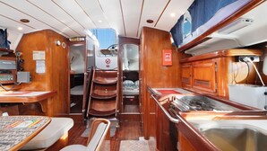 Un interior compacto y bien iluminado, con zona de comedor, pequeña kitchenette y litera.