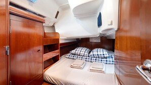 Una cabaña acogedora con cama, armario de madera y un pequeño estante.