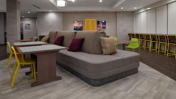 A modern lounge area with a sofa, a table, and chairs.