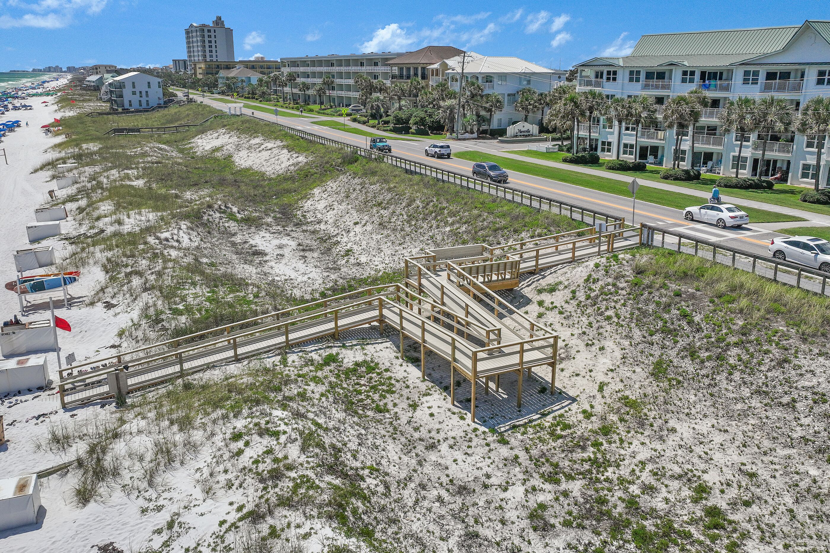 Ein Hotel an der Küste mit Blick auf den Strand, einer Promenade und einem Parkplatz.