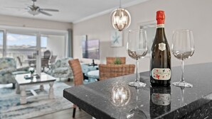 Une bouteille de vin Cuvée Clara sur un comptoir de cuisine, avec deux verres à proximité.