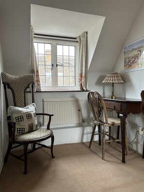Enjoy a peaceful stay in this charming room with a sloped ceiling, large window, and comfortable seating area.