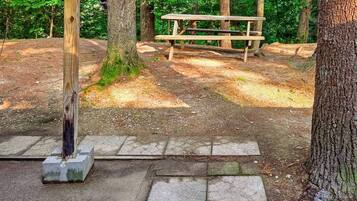 A park with a wooden picnic table and a concrete post.
