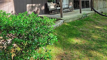 Una baita di legno con veranda, posti a sedere all'aperto e un'area coperta.