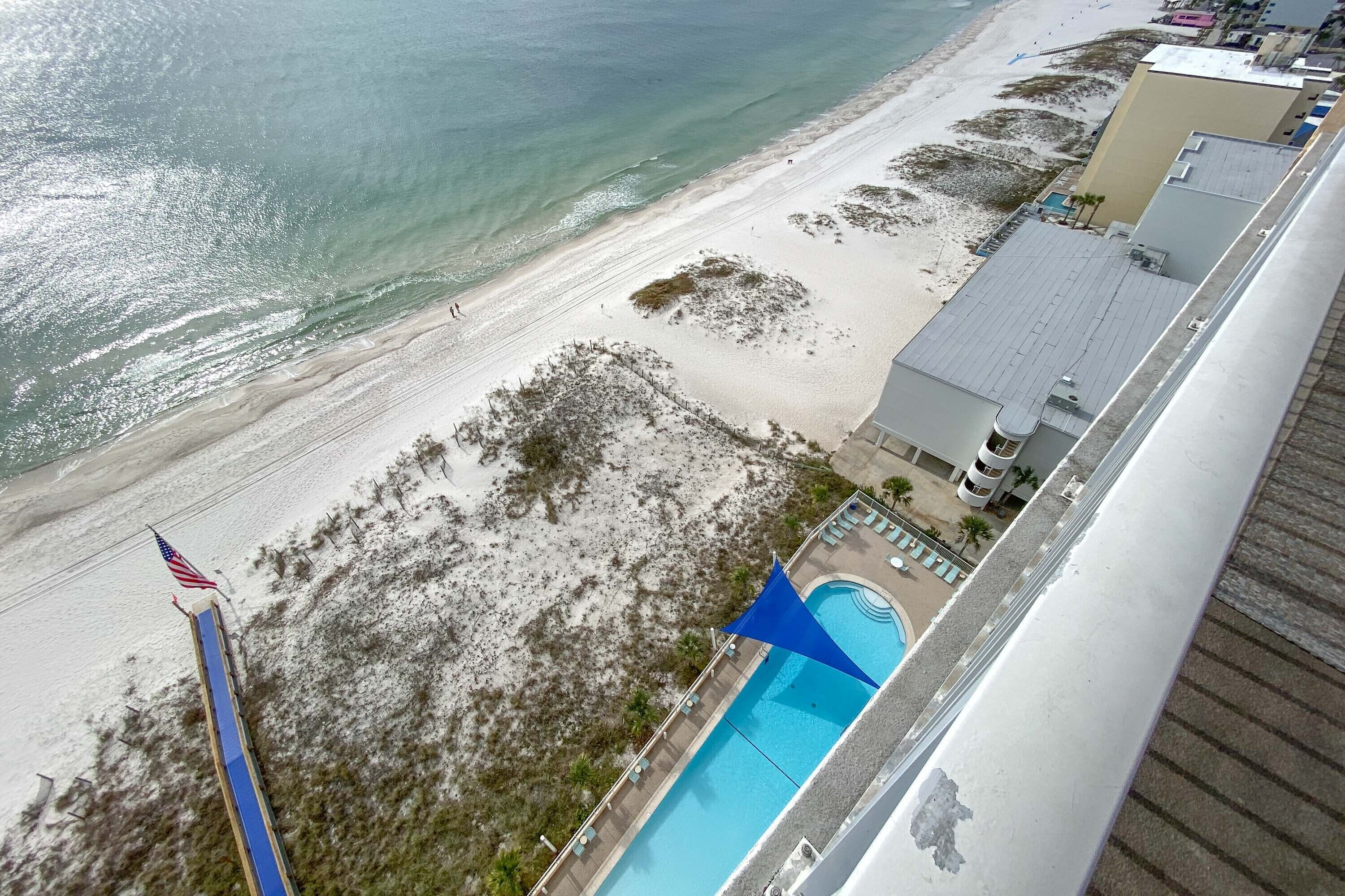 Ein Strandhotel mit Pool, einer Flagge und Blick auf den Ozean.