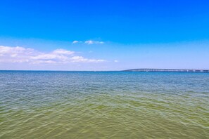 Una vista clara d'un llarg moll que s'endinsa en l'aigua sota un cel blau i radiant.