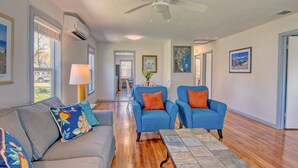 A spacious living room with a gray sofa, blue armchairs, and a wooden coffee table. - Muizenberg 6031rpb 3 Bedroom Home by RedAwning (Rockport)